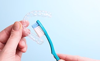 Patient cleaning clear aligner with toothbrush