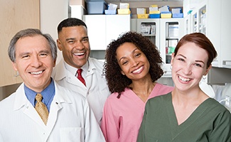 Four dental team members smiling