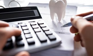 a person calculating the cost of dental implants