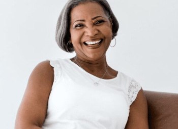 Smiling woman in white sleeveless blouse