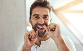 Man smiling while flossing