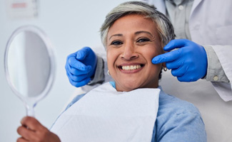 Woman pleased with her smile at the dentist’s office