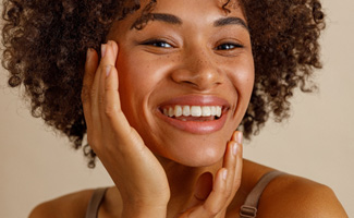 Smiling young woman touching her face