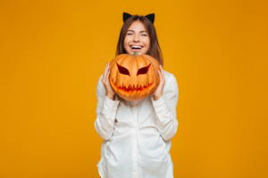 a smiling woman holding a pumpkin